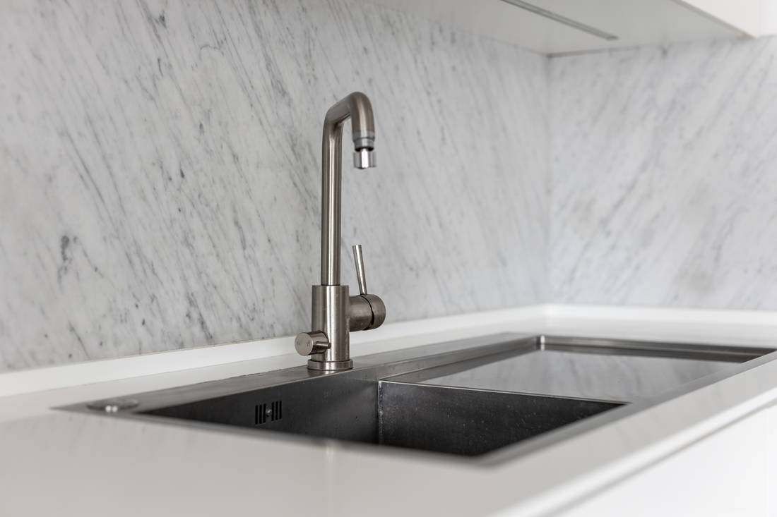 Picture of a white kitchen sink from the pattern - how to create a flowing kitchen design
