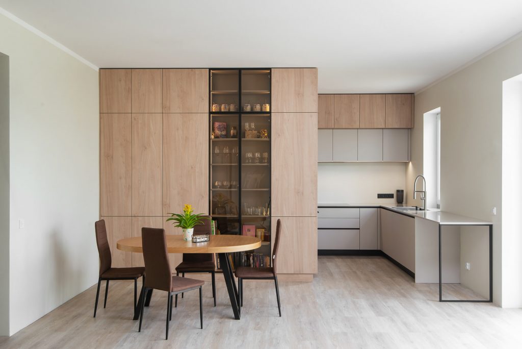 Virtuve Salaspilī ar baltām fasādēm un koka tekstūras skapi, kā arī Virtuves galdu