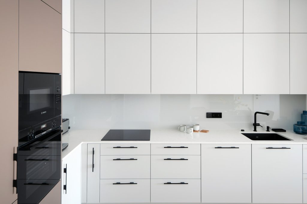Белая кухонная мебель с каменной столешницей
