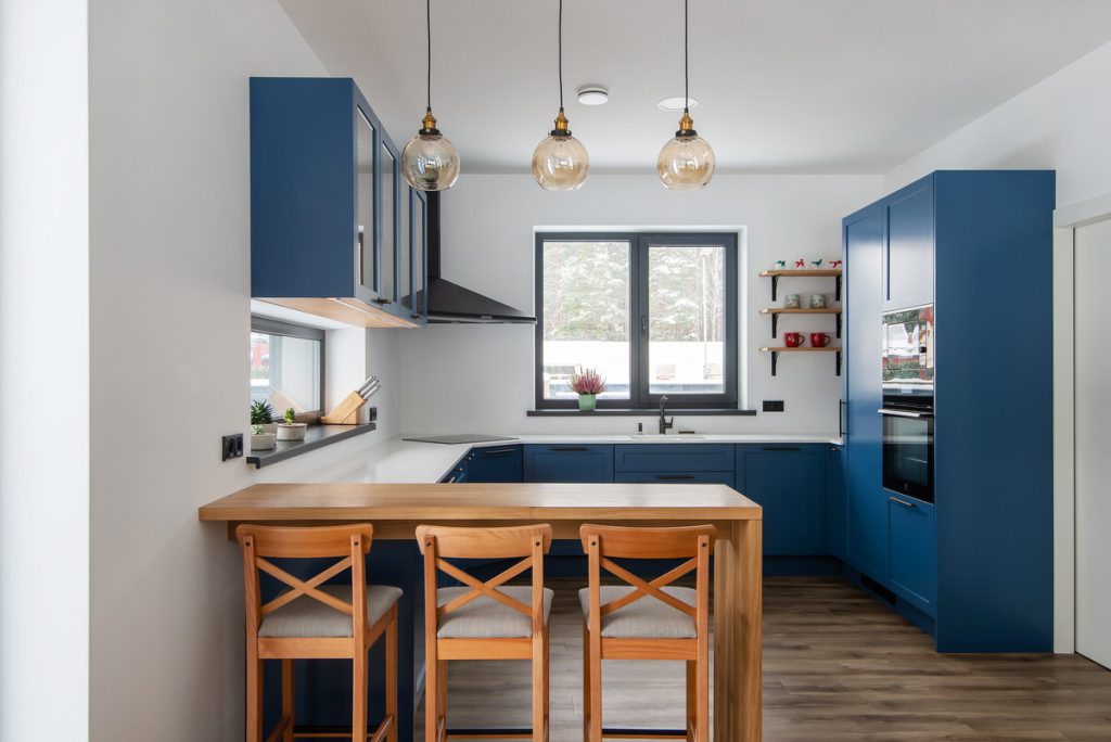 Virtuves mēbeles ar zilām fasādēm un koka salu